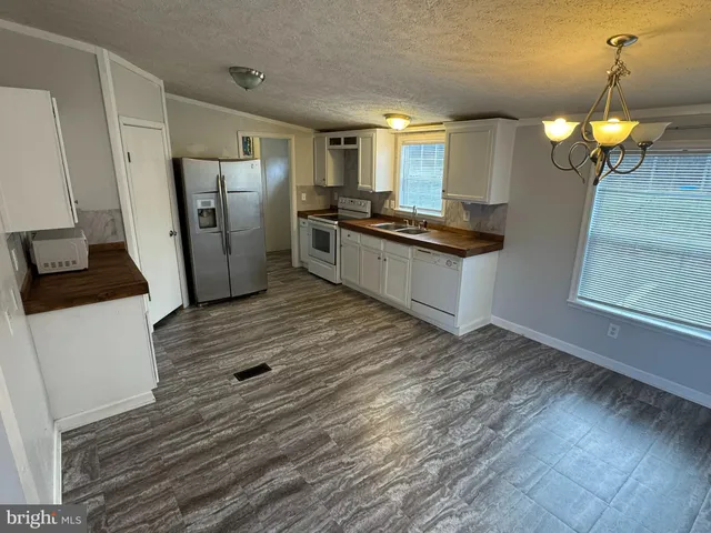 a kitchen with stainless steel appliances granite countertop a refrigerator a stove and a sink