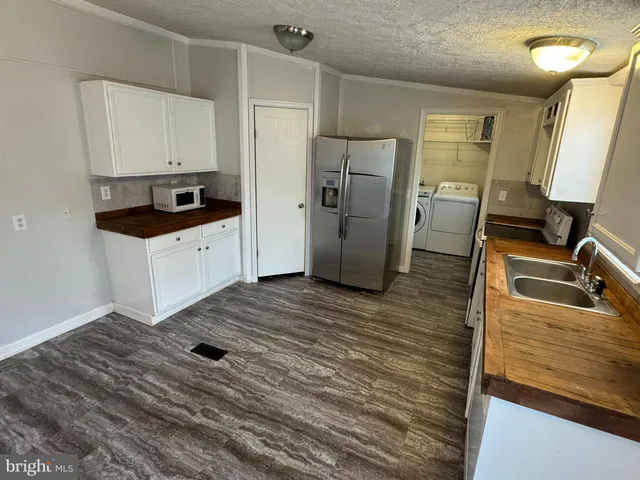 a kitchen with a refrigerator sink and wooden floor