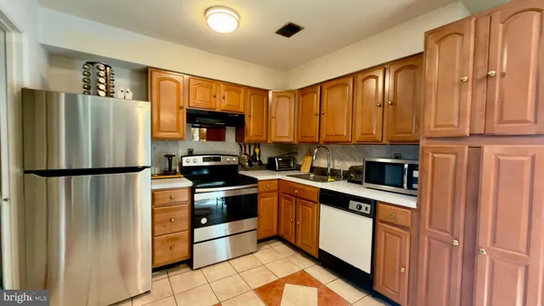 a kitchen with stainless steel appliances granite countertop a refrigerator stove and a sink