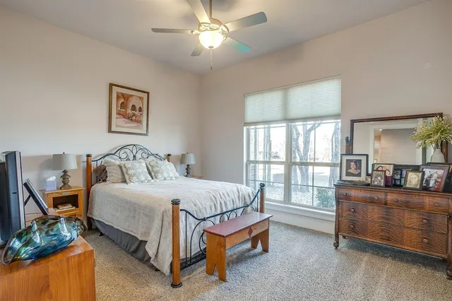 a bedroom with a bed mirror and window