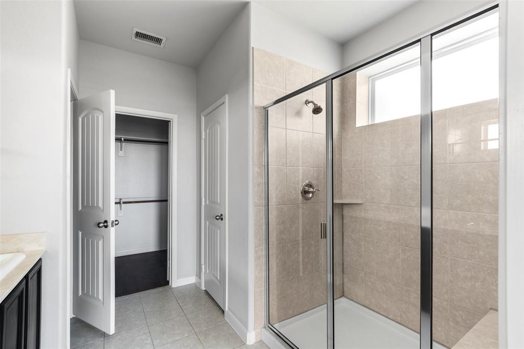 4650 Elderberry Street Forney, TX 75126 - Photo 13 of 31 a bathroom with a glass shower door