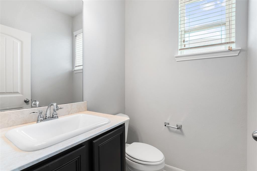 4650 Elderberry Street Forney, TX 75126 - Photo 16 of 31 a bathroom with a sink a toilet and a window