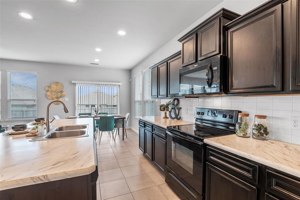 4650 Elderberry Street Forney, TX 75126 - Photo 6 of 31 a kitchen with stainless steel appliances granite countertop a sink stove and cabinets