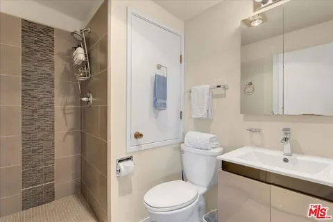 a bedroom with a bed and a lamp on dresser