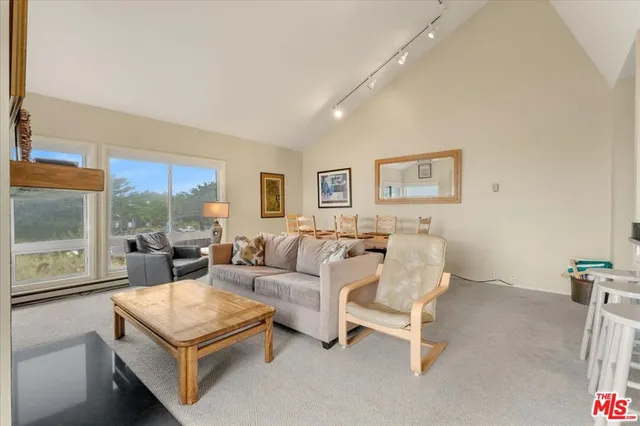 a living room with furniture and a view of kitchen