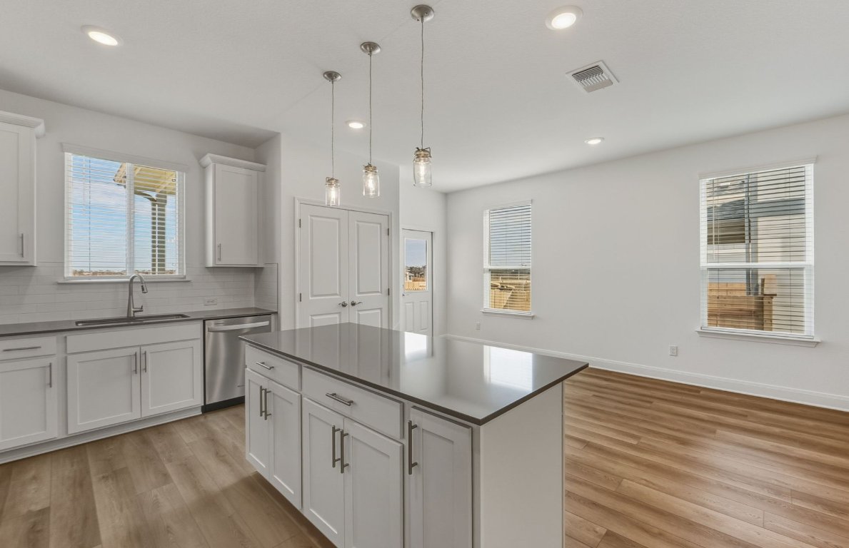 216 Daniels Dusty Trail Georgetown, TX 78626 - Photo 4 of 23 a large kitchen with kitchen island a sink stainless steel appliances and cabinets