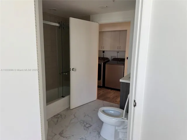 a bathroom with a granite countertop toilet and a sink