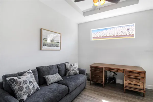 a living room with furniture a ceiling fan and a window