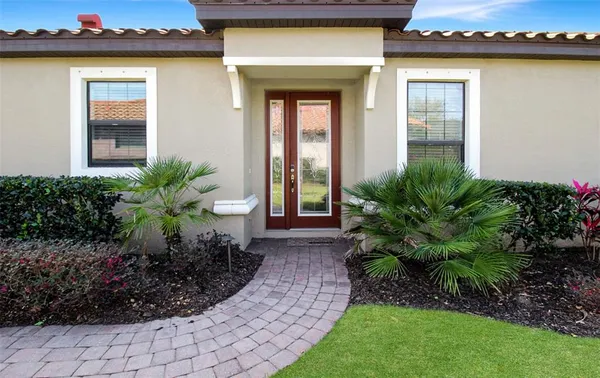 a view of a house with a small yard and potted plants