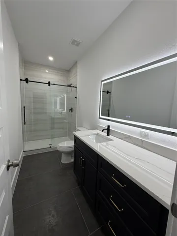a view of kitchen with stainless steel appliances wooden cabinets and entryway