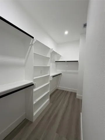 a view of walk in closet with empty racks