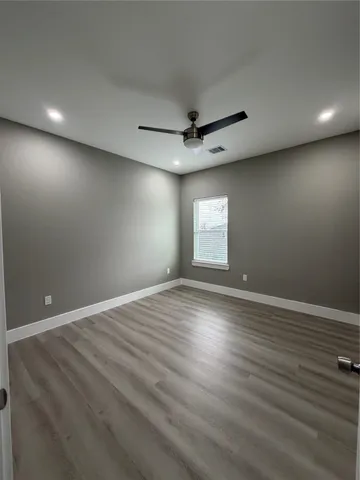 an empty room with window and wooden floor