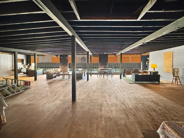 a living room with furniture pool table and large windows