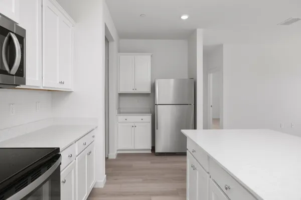 a kitchen with a refrigerator a stove and cabinets