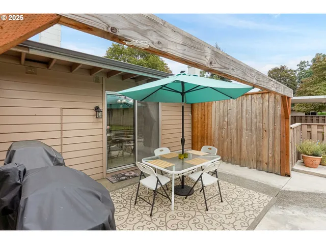 a patio with a table and chairs under an umbrella