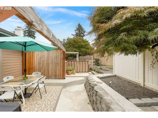 a view of a patio with a table and chairs under an umbrella