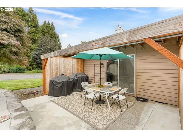 a view of a patio with a table and chairs under an umbrella