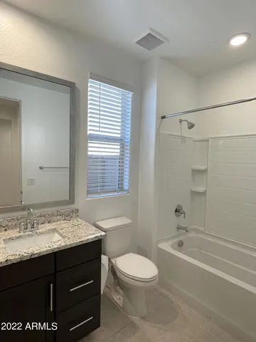 a bathroom with a granite countertop sink toilet a shower and a bathtub