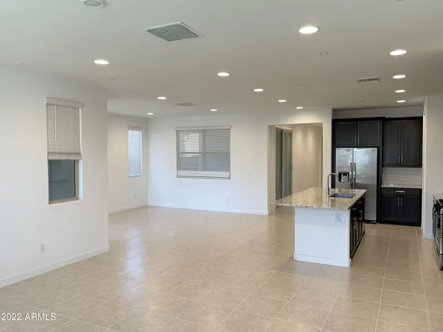 a large kitchen with a large counter top stainless steel appliances and cabinets