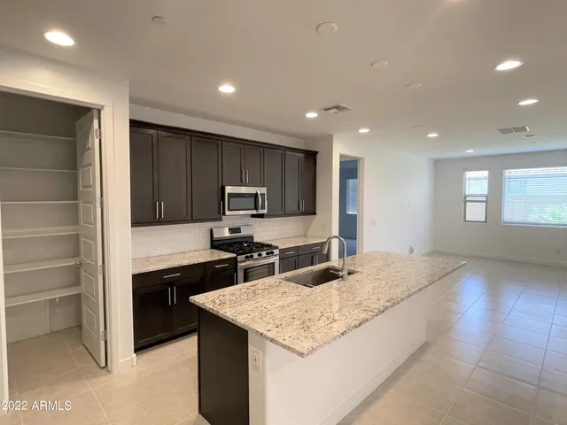 a kitchen with stainless steel appliances granite countertop a sink stove and refrigerator