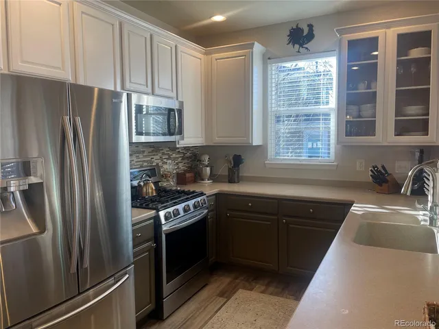 a kitchen with stainless steel appliances granite countertop a refrigerator sink and stove