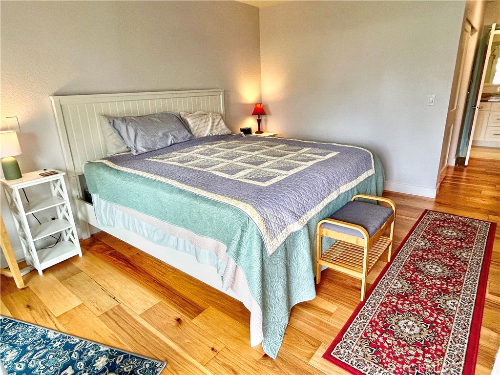 258 West Escalones, Unit 6R San Clemente, CA 92672 - Photo 27 of 37 a bedroom with a bed and wooden floor