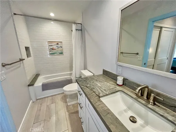 a bathroom with a granite countertop sink and a mirror