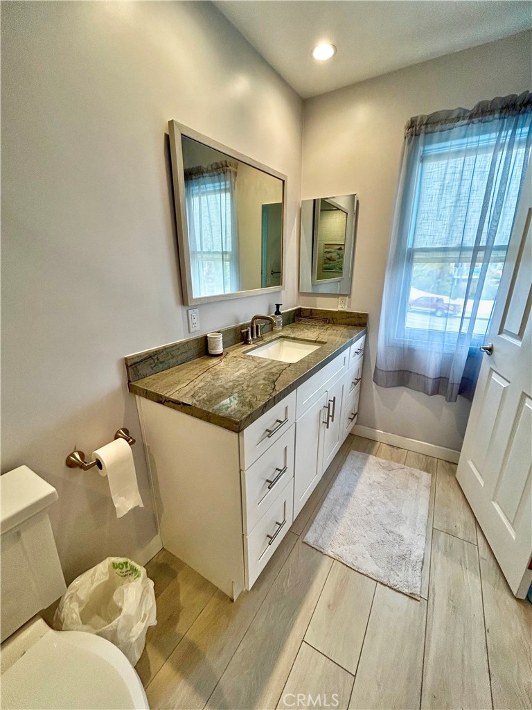 258 West Escalones, Unit 6R San Clemente, CA 92672 - Photo 31 of 37 a bathroom with a granite countertop sink and a mirror