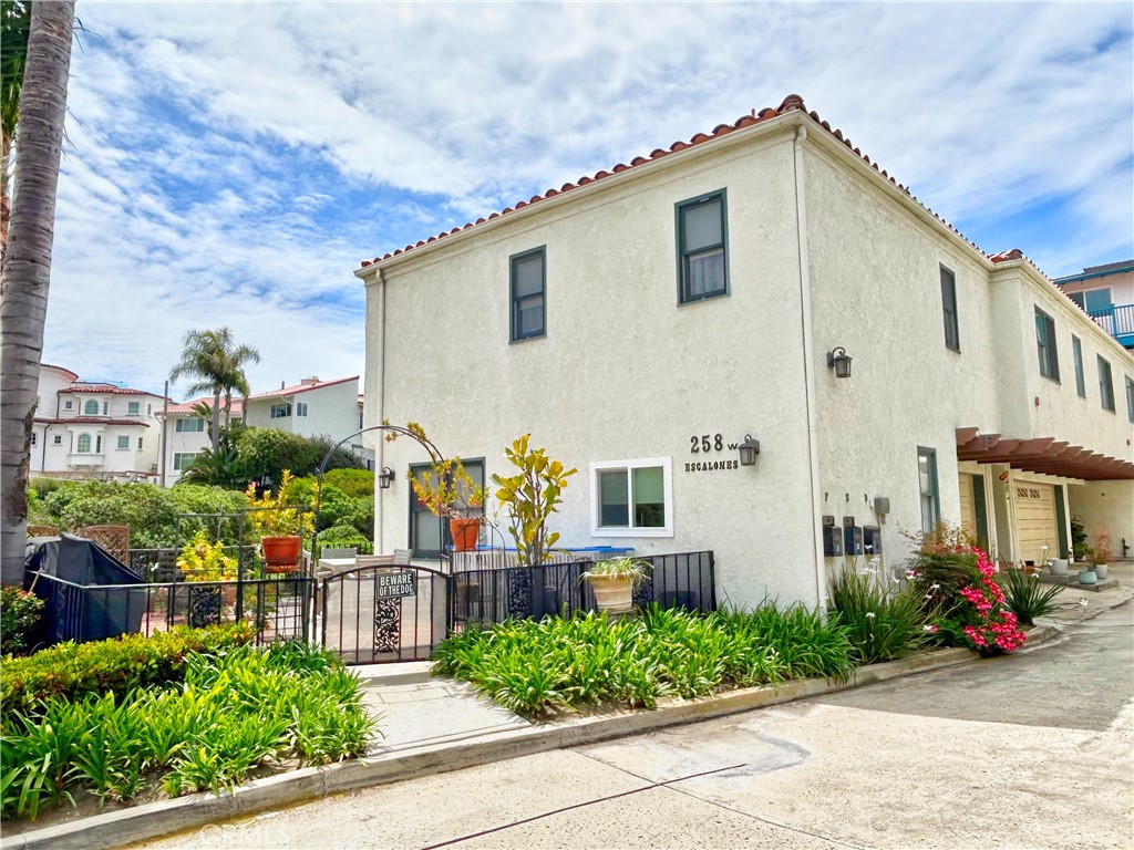 258 West Escalones, Unit 6R San Clemente, CA 92672 - Photo 7 of 37 a view of a house with potted plants and a bench