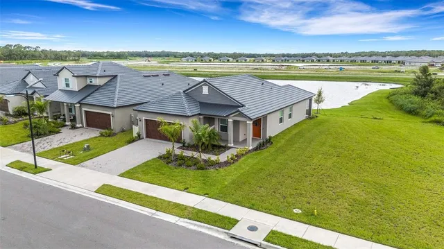 an aerial view of residential houses with outdoor space and ocean view