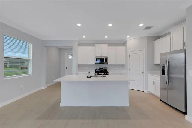 a kitchen with stainless steel appliances white cabinets and a stove top oven
