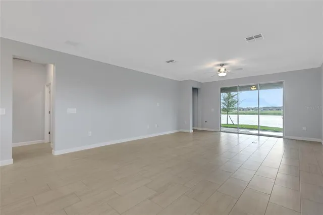 an empty room with a chandelier fan