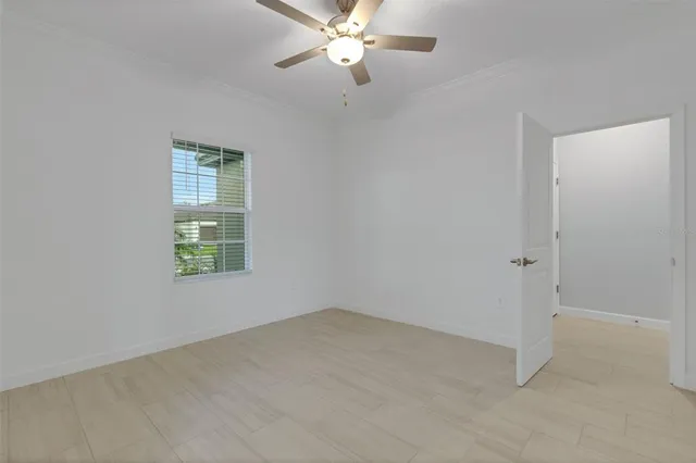 an empty room with a window and a ceiling fan