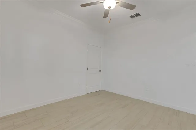 an empty room with a window and a ceiling fan