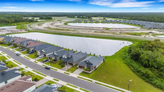 a kitchen with stainless steel appliances a sink a stove a refrigerator and white cabinets