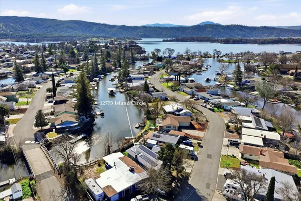 an aerial view of a city with lots of residential buildings ocean and mountain view in back