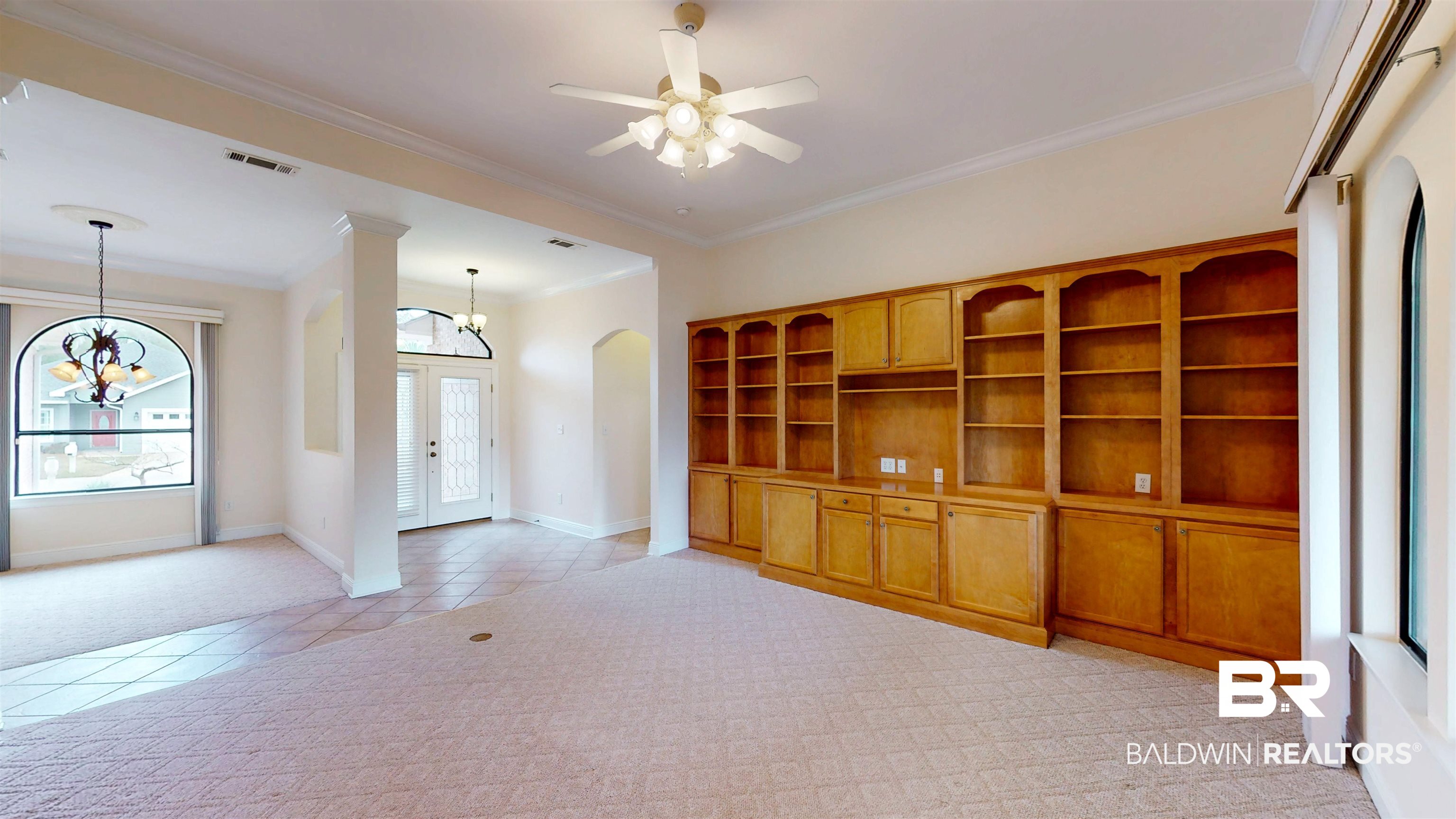 214 Hemingway Loop Foley, AL 36535 - Photo 10 of 67 Unfurnished living room with crown molding, french doors, arched walkways, light carpet, and a chandelier