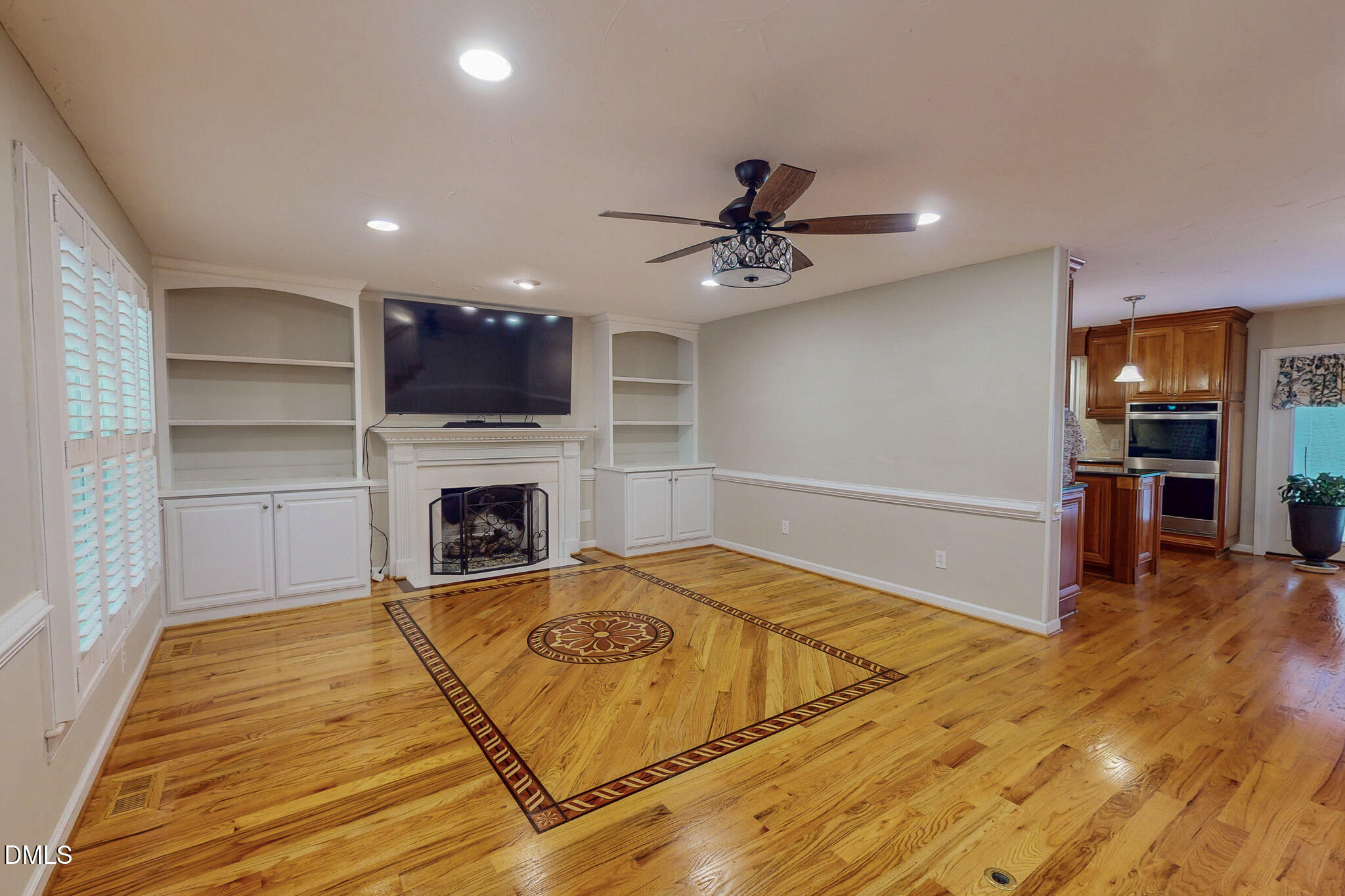 2428 Helena Moriah Road Timberlake, NC 27583 - Photo 2 of 73 a view of a livingroom with a fireplace a ceiling fan and wooden floor