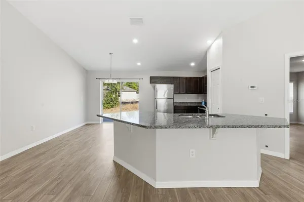 a large white kitchen with a large counter top and stainless steel appliances
