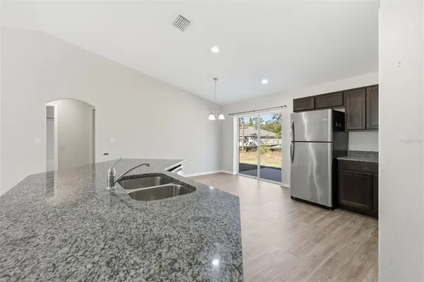 a kitchen with stainless steel appliances granite countertop a refrigerator and a sink