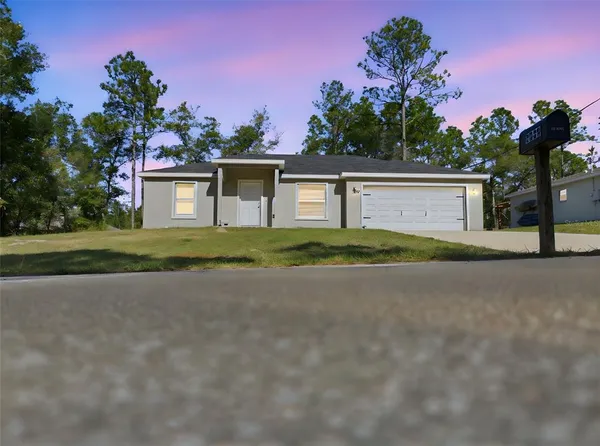 a front view of a house with a yard and a garage