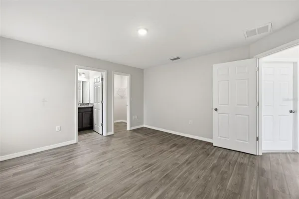 a view of an empty room with wooden floor