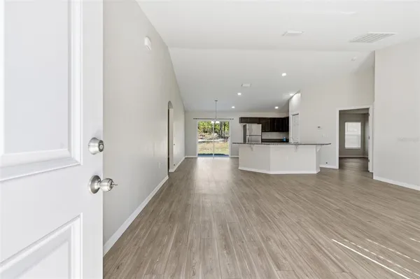 a view of a kitchen with wooden floor and electronic appliances