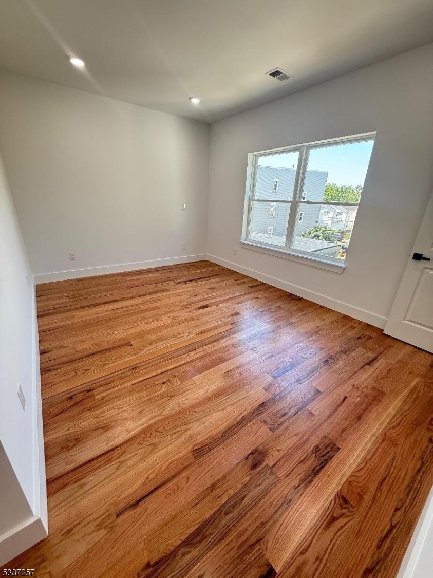 715 South 17th Street, Unit 2 Newark, NJ 07103 - Photo 18 of 24 an empty room with wooden floor and windows