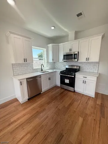 a large kitchen with cabinets and wooden floor