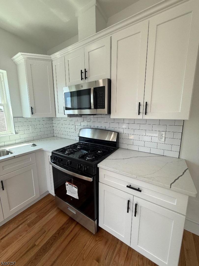 715 South 17th Street, Unit 2 Newark, NJ 07103 - Photo 4 of 24 a kitchen with stainless steel appliances white cabinets granite counter tops and a stove