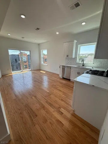 a kitchen with stainless steel appliances granite countertop a stove and a wooden floors