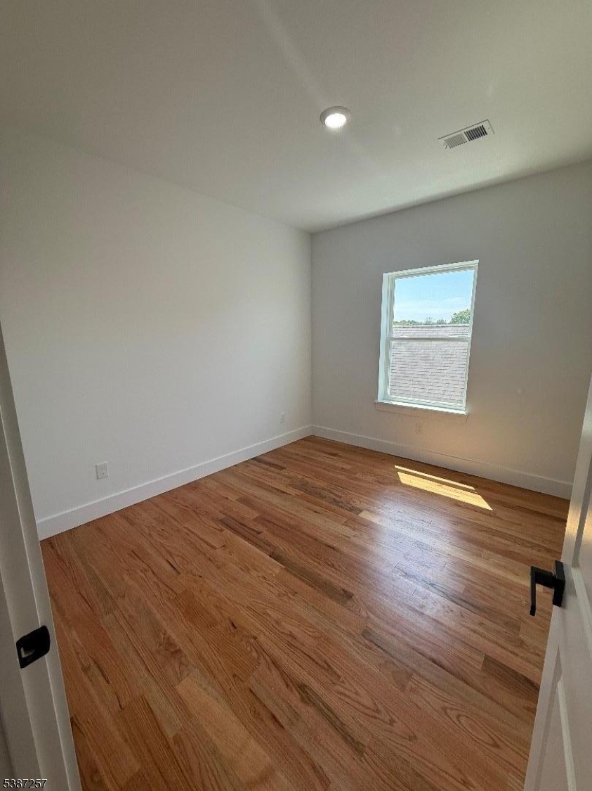 715 South 17th Street, Unit 2 Newark, NJ 07103 - Photo 7 of 24 an empty room with wooden floor and windows