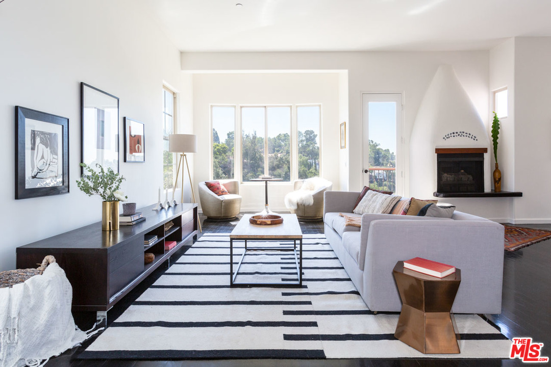 a living room with furniture a flat screen tv and a large window