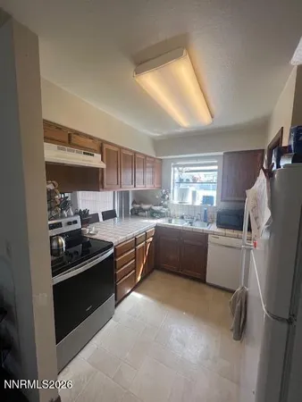 a kitchen with sink refrigerator and window